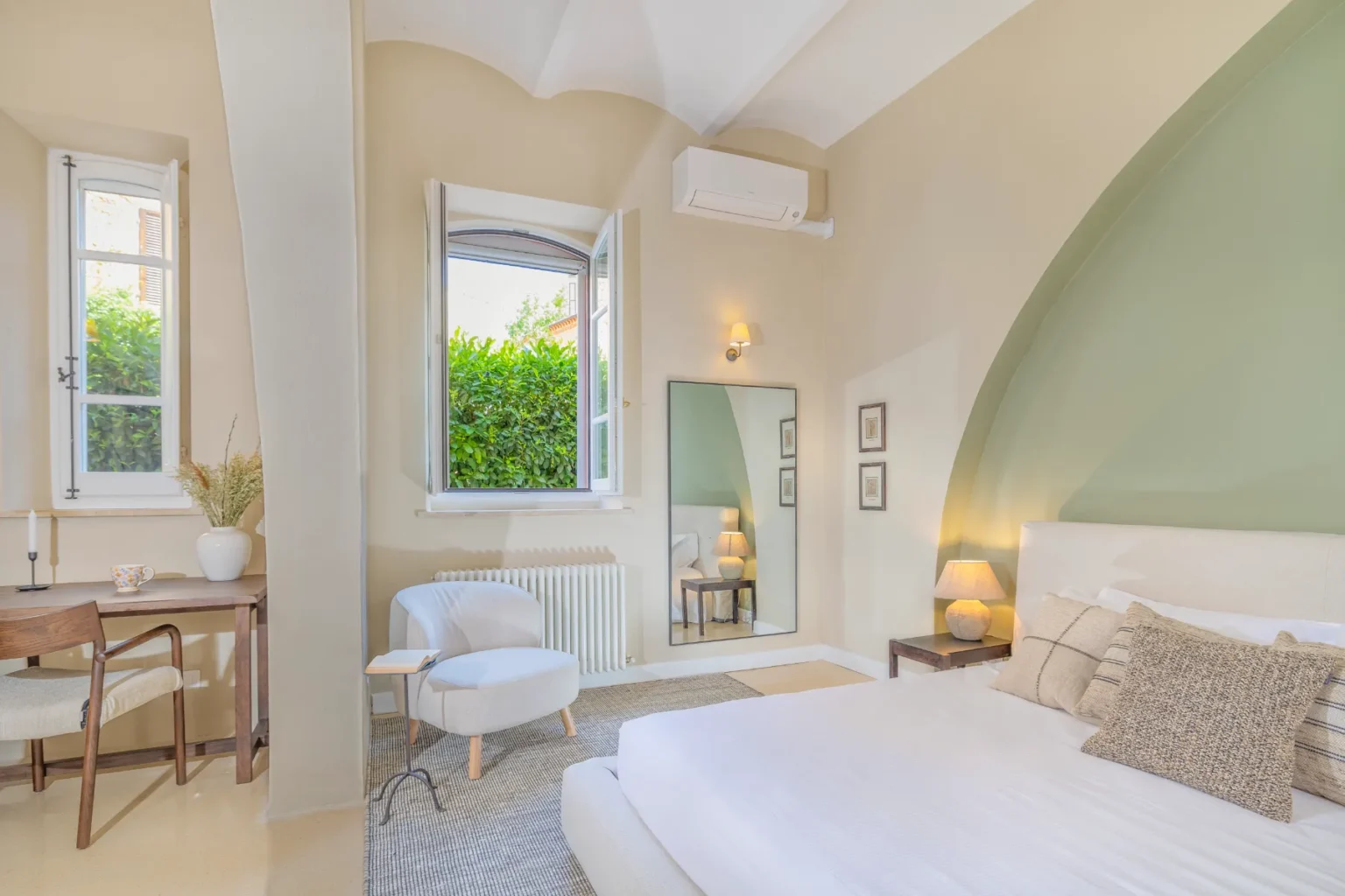Modern bedroom with large windows, ambient lighting, and minimalist decor, featuring a comfortable bed, cozy seating area, and a stylish mirror, ideal for relaxation and comfort. | Only on SopranoVillas