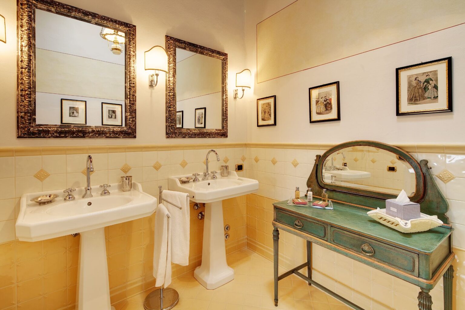 Elegant bathroom featuring vintage fixtures, dual sinks, decorative mirrors, and a stylish green vanity. The warm yellow tile adds a cozy touch, complemented by framed artwork on the walls. | Only on SopranoVillas