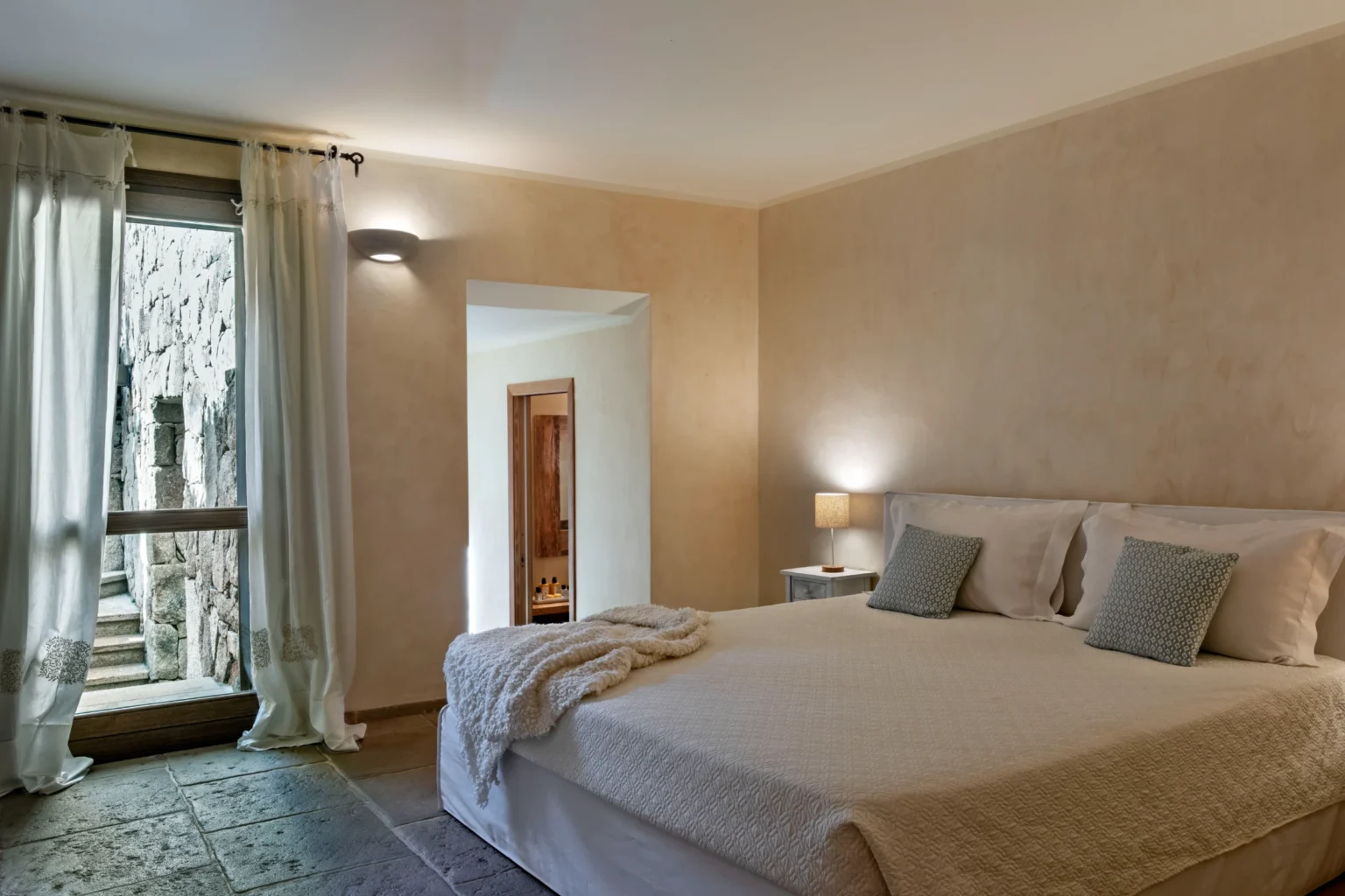 Luxury villa bedroom in Italy featuring a spacious layout, elegant decor, large windows with natural light, and a comfortable king-size bed, perfect for a relaxing getaway. | Only on SopranoVillas