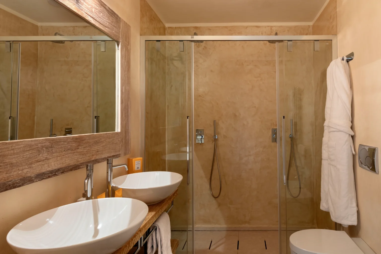 Luxury villa bathroom in Italy featuring modern design, glass shower, elegant sinks, and natural stone finishes, ideal for a relaxing getaway. | Only on SopranoVillas