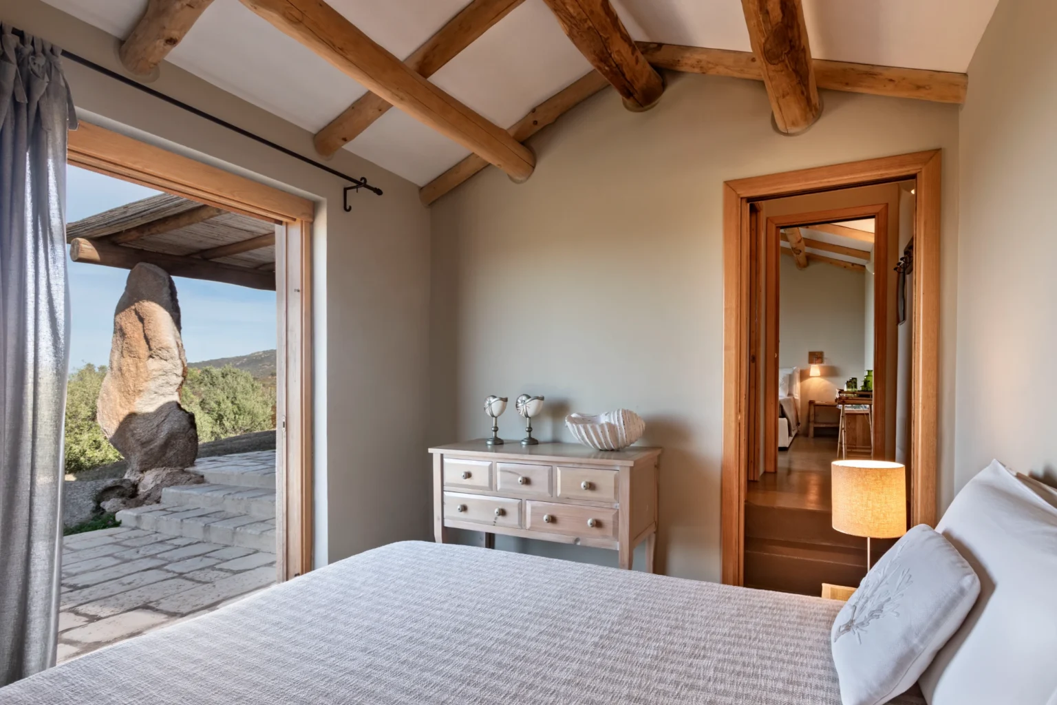 Luxurious bedroom interior of a villa in Italy, featuring a comfortable bed, elegant decor, and large windows showcasing scenic views. Ideal for travelers seeking a serene getaway. | Only on SopranoVillas
