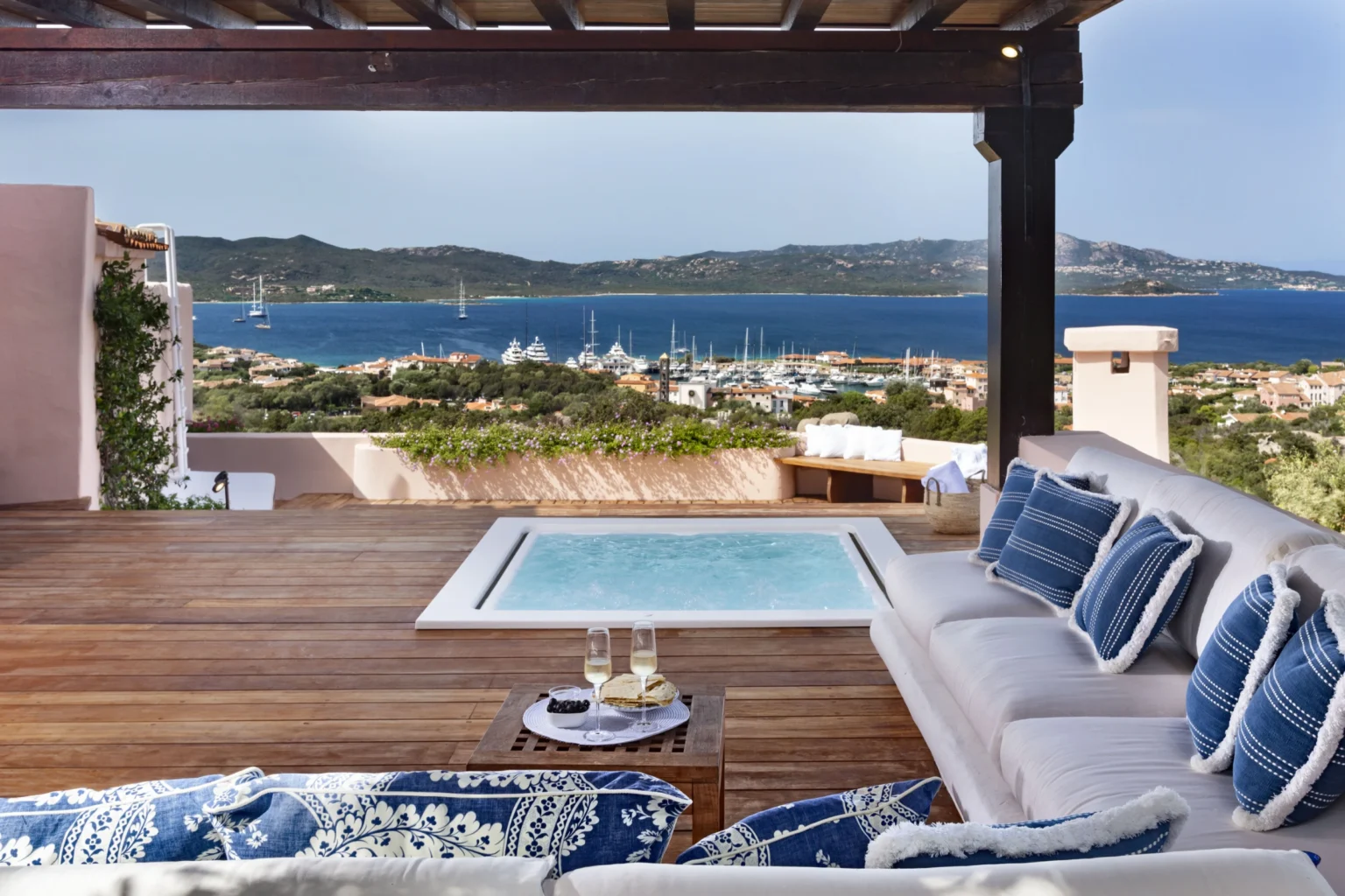 Luxurious outdoor terrace with a hot tub, comfortable seating, and a stunning view of the coastline and marina. Perfect for relaxation and enjoying scenic sunsets. | Only on SopranoVillas