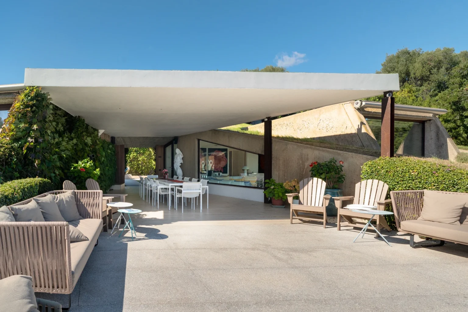 Modern outdoor patio featuring stylish seating, a large shade canopy, and a landscaped garden view, ideal for relaxation and entertaining. | Only on SopranoVillas