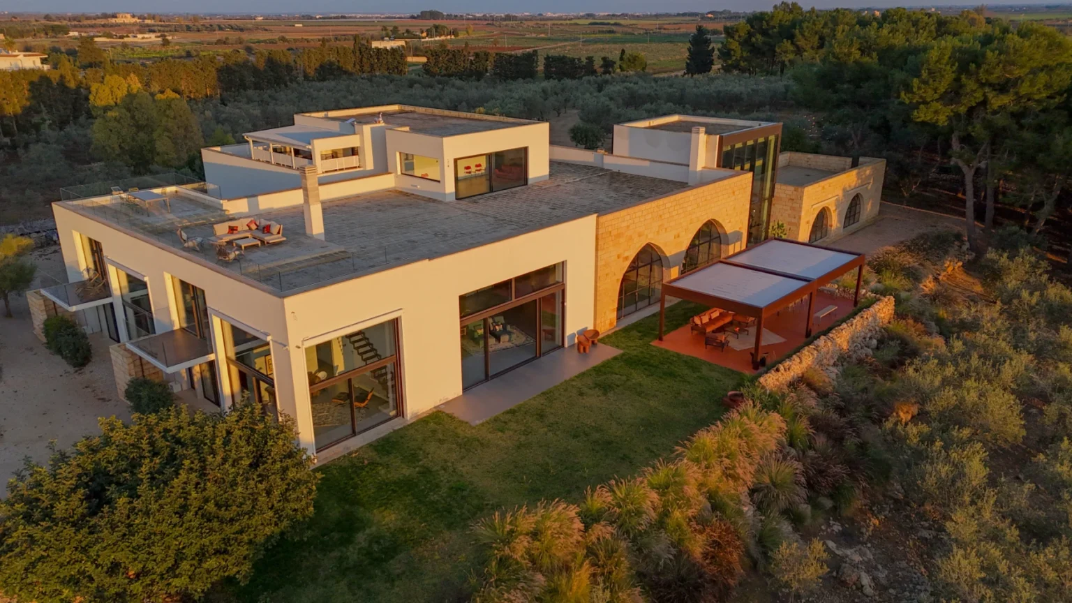 Modern luxury home with expansive outdoor space, surrounded by lush greenery and scenic views, showcasing contemporary architecture and stylish design elements. | Only on SopranoVillas