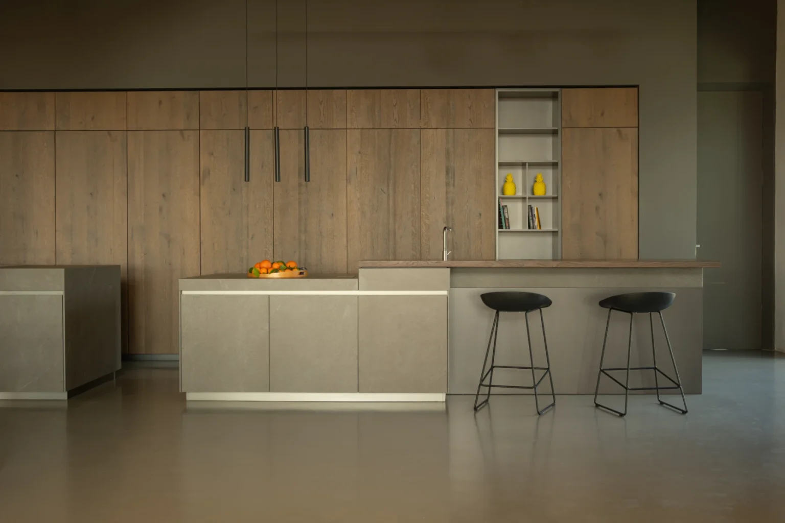 Modern kitchen design featuring sleek stainless steel cabinetry, wooden accents, a central island with an orange centerpiece, and minimalist bar stools. The space emphasizes contemporary aesthetics and functionality. | Only on SopranoVillas