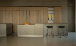 Modern kitchen design featuring sleek stainless steel cabinetry, wooden accents, a central island with an orange centerpiece, and minimalist bar stools. The space emphasizes contemporary aesthetics and functionality.