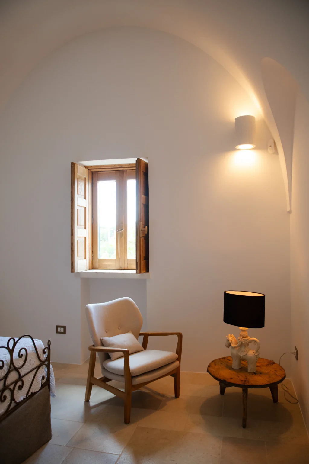 Interior view of a bright room featuring a wooden window with shutters, a modern chair, and a lamp, highlighting a minimalist design aesthetic. | Only on SopranoVillas