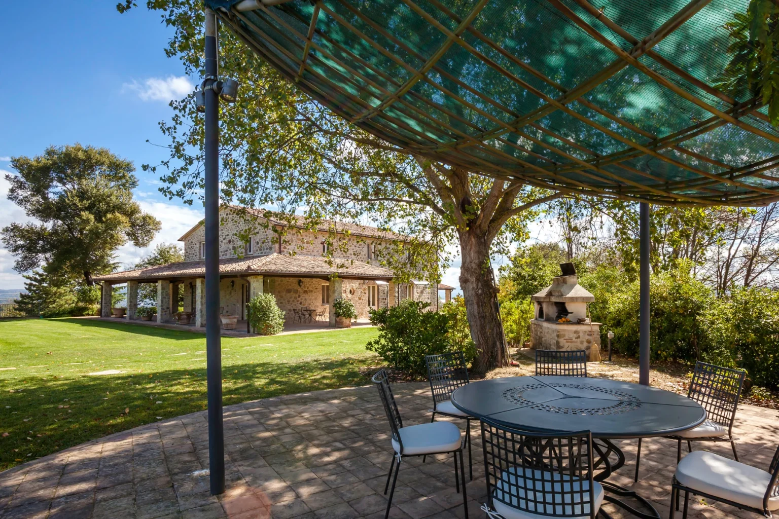 Bisenzio_Elegant_Farmhouse_Shaded_Garden_Dining_Area_Pizza_Oven.webp | Only on SopranoVillas