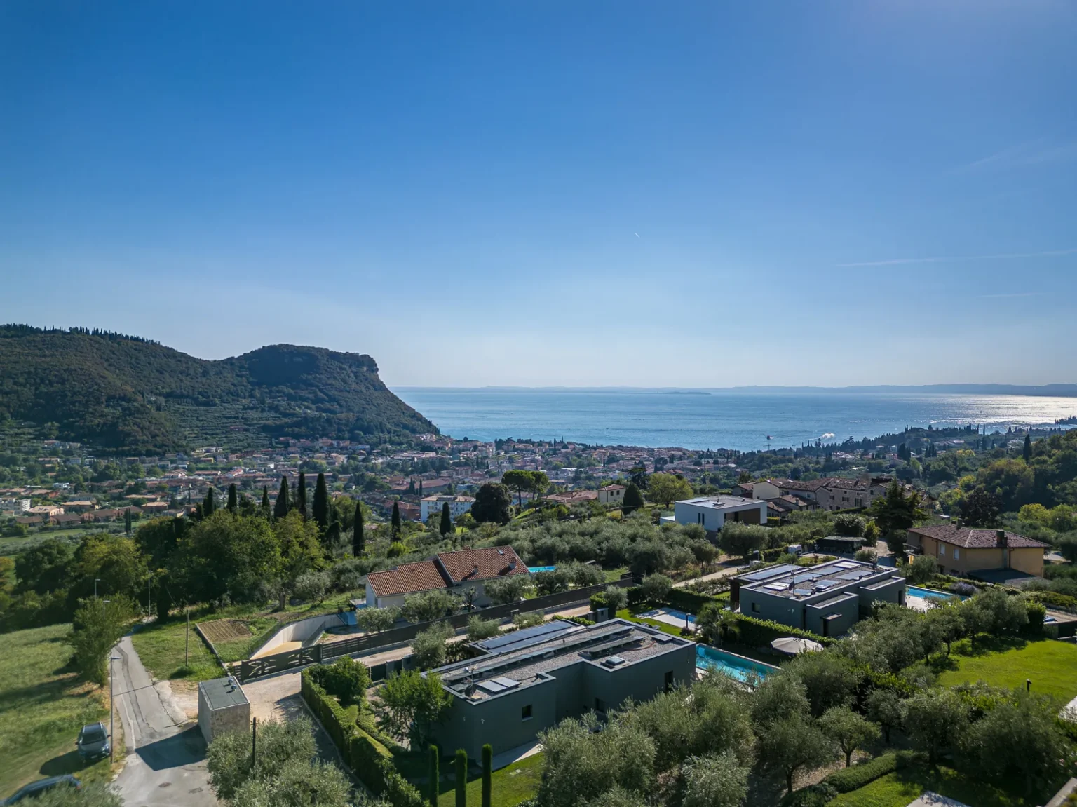 Aerial view across the villa and surrounding hillside towards the lake. | Only on SopranoVillas