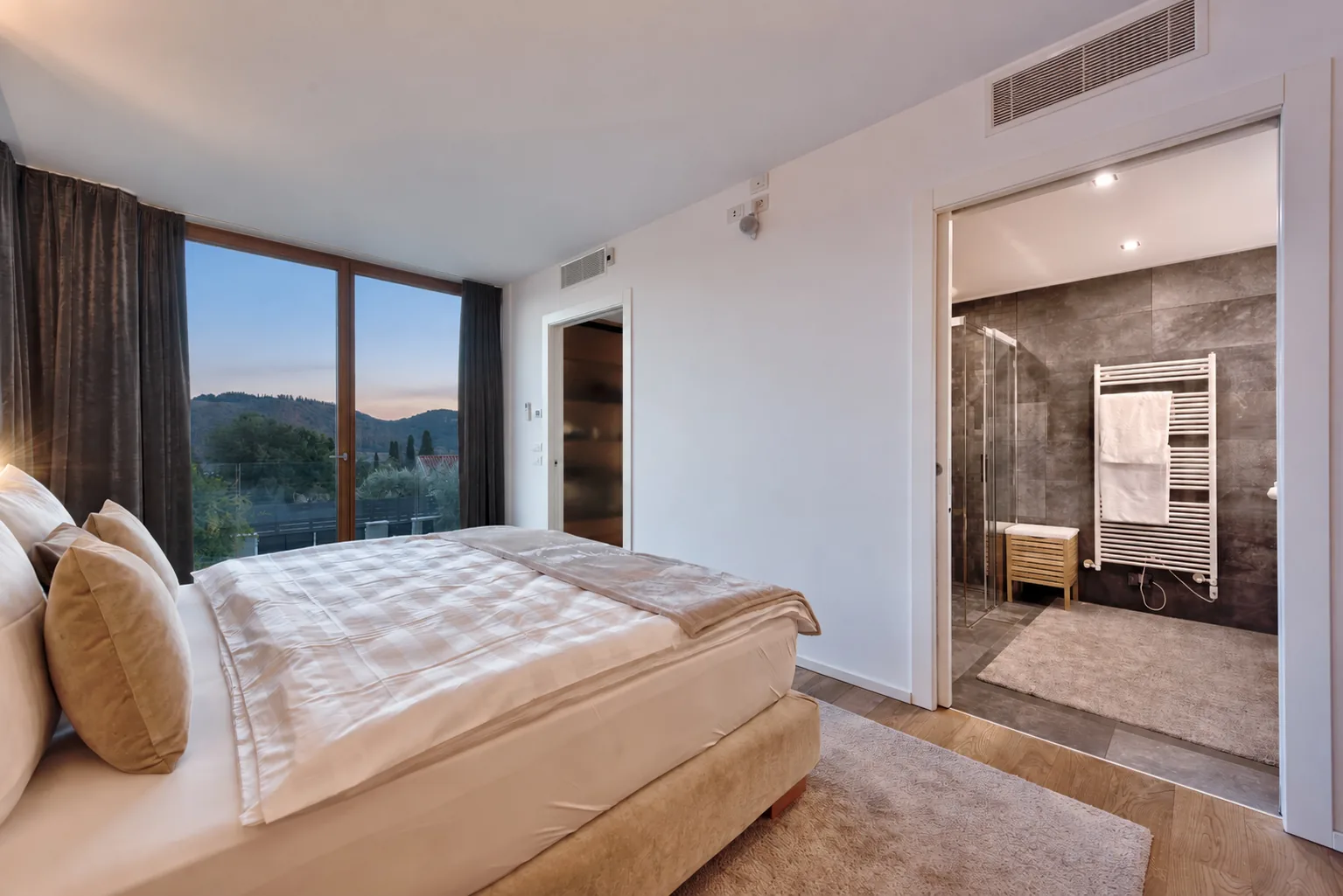 Bedroom with a large window and an open doorway to a grey-tiled bathroom. | Only on SopranoVillas