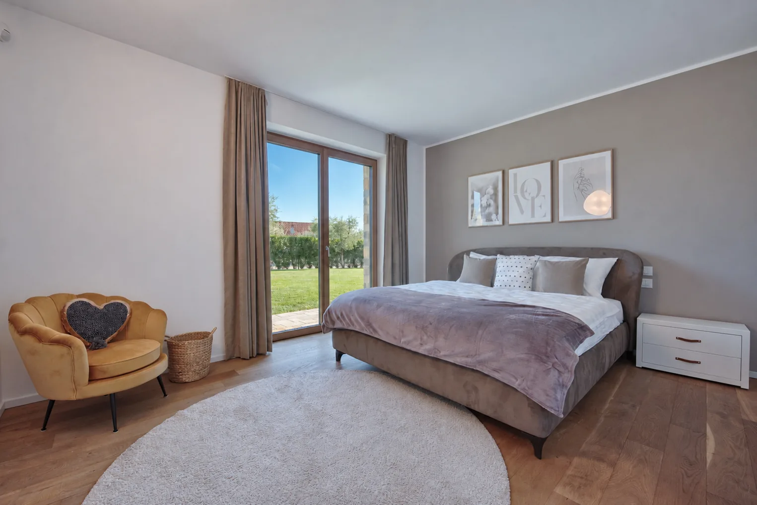 Bedroom with a yellow armchair, grey bedding and a glazed door facing the garden. | Only on SopranoVillas