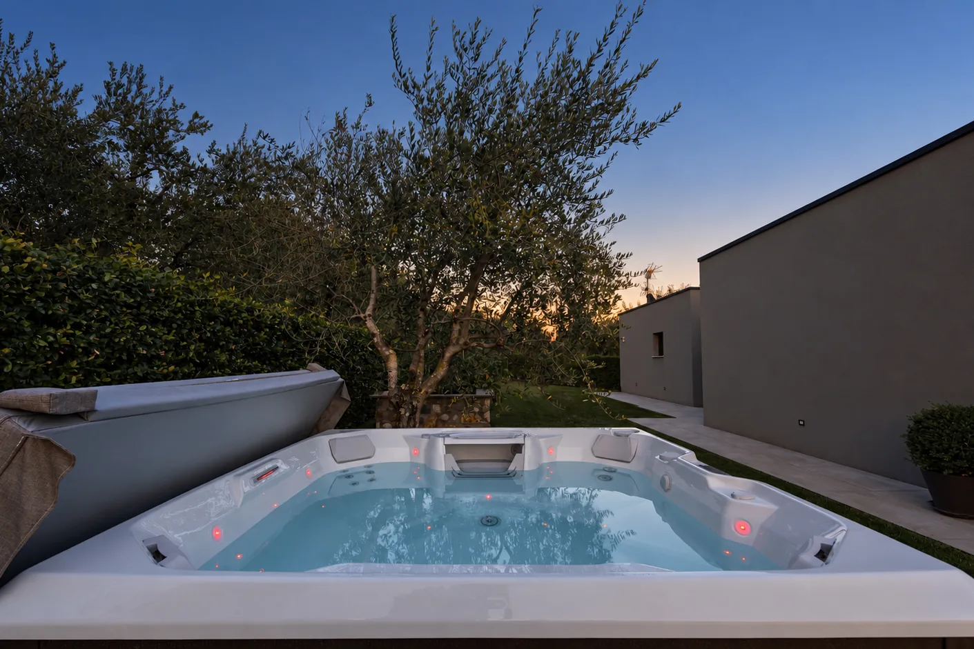 Outdoor hot tub with bubbling water, surrounded by trees at dusk. | Only on SopranoVillas