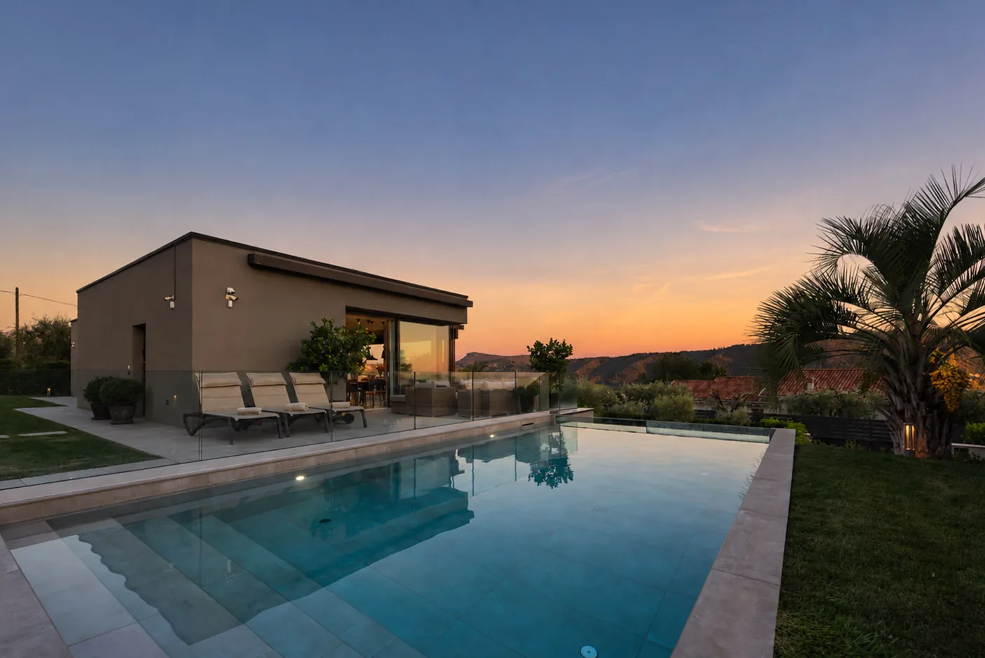 Swimming pool beside the villa at sunset, with trees and hills in the background. | Only on SopranoVillas