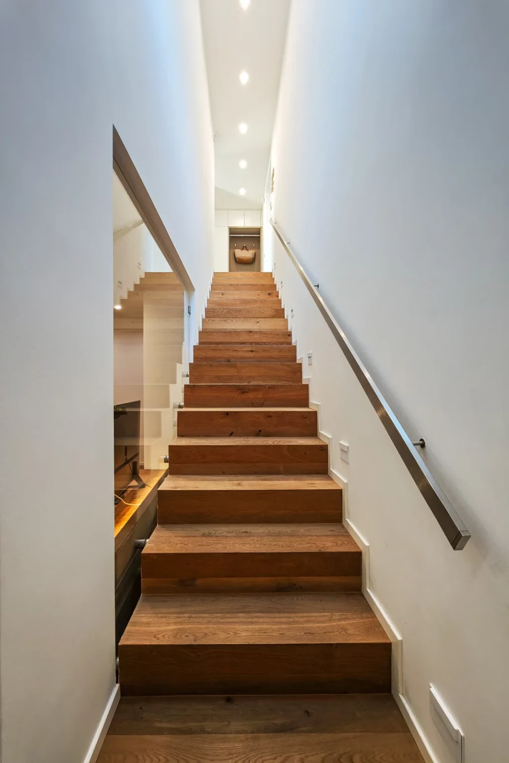 Timber staircase with white walls, recessed lighting and handrails on both sides. | Only on SopranoVillas