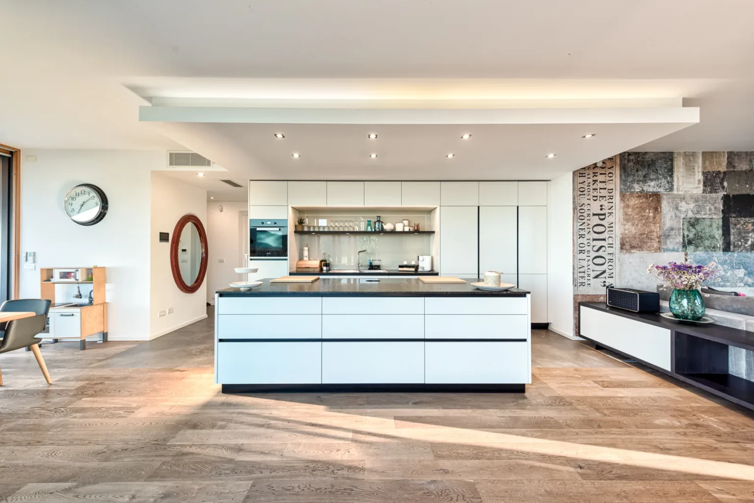 Kitchen with a white island, built-in cabinetry, wood flooring and a textured feature wall. | Only on SopranoVillas
